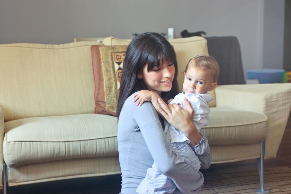 A mother lovingly embracing her baby on a comfortable sofa